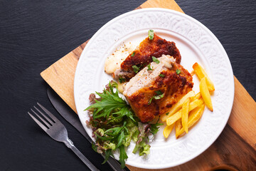 Food concept Homemade Veal cordon bleu with salad and french fried in white ceramic plate on wooden...
