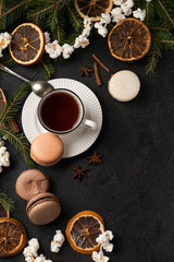 Fototapeta na wymiar Tea cup with macarons in Christmas decorations
