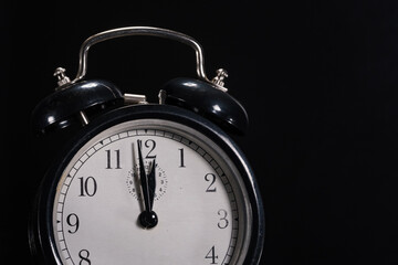 1 minute to 12 shown on old retro alarm clock. For topics like climate change, deadlines, danger ... lot of copy space.