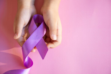 Child hands holding purple ribbons, Alzheimer's disease, Pancreatic cancer, Epilepsy awareness, world cancer day