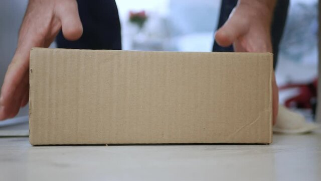 Man Taking a Postal Package from the Front of the Door, Delivered by a Postal Courier. Packages Delivering with Postal Services.