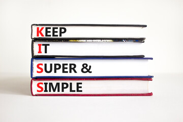 KISS keep it super and simple symbol. Concept words KISS keep it super and simple on books. Beautiful white table, white background. Business KISS keep it super and simple concept. Copy space.