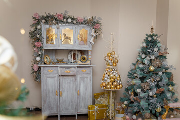 Beautiful shebby chic cupboard decorated with artificial snowy fir branches, icy roses, rocking horse toy, golden Christmas garland lights boke