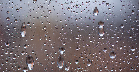 Water drops or pieces of ice on the glass. Autumn cooling rainy weather. Close-up.