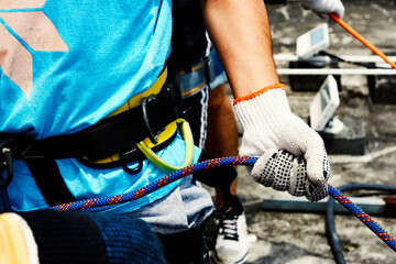 Close-up of a gloved hand holding a rappel rope.