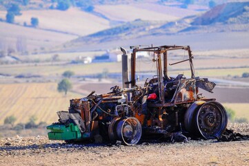 Tractor destroyed by fire in the middle of the field.