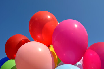 bunch of multicolored balloons in the city festival on clear blue sky background
