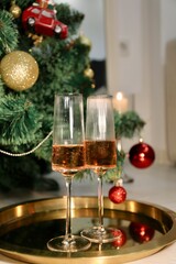 Selective focus glasses of champagne near the new year tree in the new year 2022