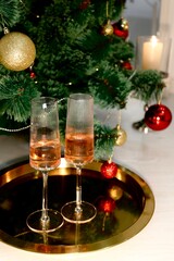 Fototapeta na wymiar Selective focus glasses of champagne near the new year tree in the new year 2022