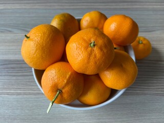 Mandarins, mandarins in a bowl on the wooden table background. Citrus concept idea and selective focus.