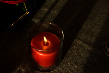 Red candle in a  glass container.