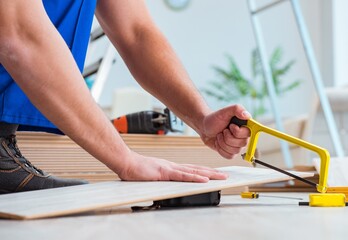 Repairman laying laminate flooring at home