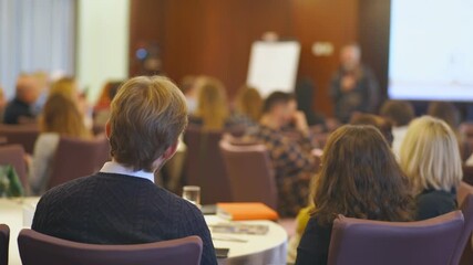 Speaker giving a talk in conference hall at business event. Audience at the entrepreneurship symposium.