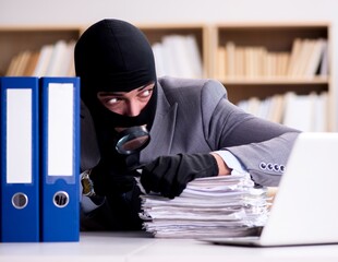 Criminal businessman wearing balaclava in office