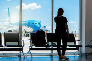 Mujer en zona de embarque esperando para abordar su avión