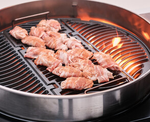 Bacon wrapped chicken wings on the grill, close up