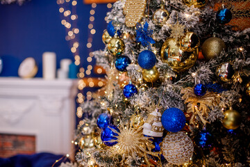Blue balls and gold tinsel decorate the Christmas tree.