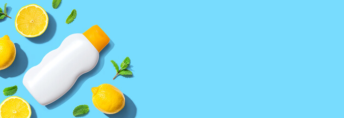 Sunblock bottle with yellow lemons - flat lay