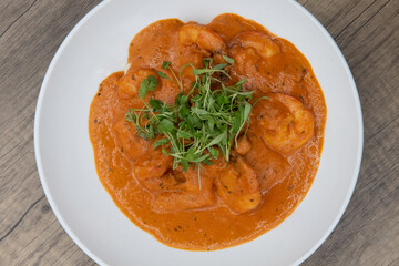 Overhead view of artistic presentation of shrimp smothered in chorizo sauce for a fusion blend of...