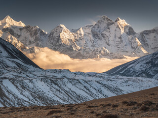 Lighting clouds between snow peaks in valley Khumbu in Nepal