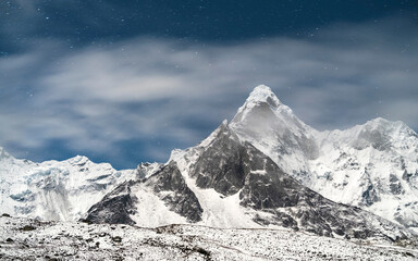 Night sky with clouds above summit Ama Dablam in Nepal