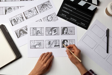 The artist draws a storyboard for the film. The director creates the storytelling by sketching footage of the script on paper. - 474441032