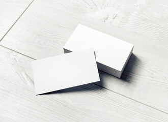 Blank business cards on light wooden background. Mockup for branding identity. Template for graphic...