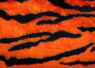 Tiger fur background. Background with a pattern of tiger stripes, tiger color. Tiger skin texture, artificial fur. 