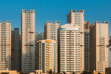 Fototapeta na wymiar New Residential Multi-storey Houses On Blue Sky. Real Estate, Development Industry. UAE