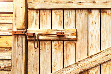 Wooden door to the barn or horse stall, lock on the door.