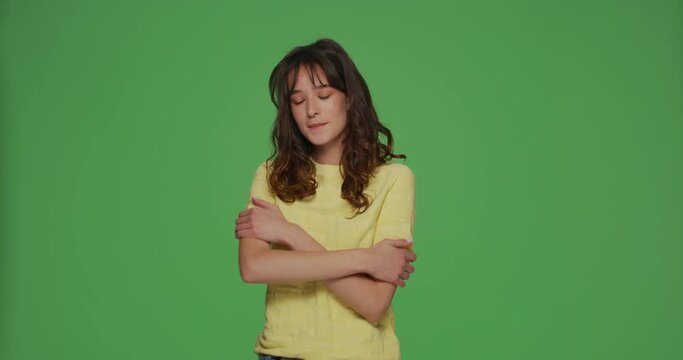 Self love. Beautiful young girl embracing herself smiling with pleasure, self-acceptance and self-confidence concept