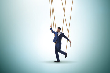 Businessman puppet being manipulated by ropes