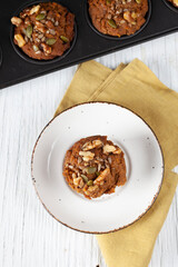 Overhead view of a fresh apple muffin on a plate with muffin tin