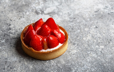 Strawberry tart with custard on grey background close-up - 474444040