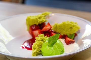 Dessert with sponge cake and strawberries is on the plate.