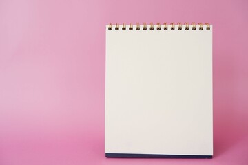 A paper white calendar stands on the table. Mock Up Vector Template. Blank Calendar on pink background.