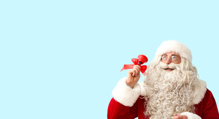 Santa Claus with Christmas bell on blue background with space for text