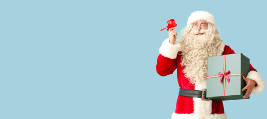 Santa Claus with Christmas bell and gift on blue background with space for text