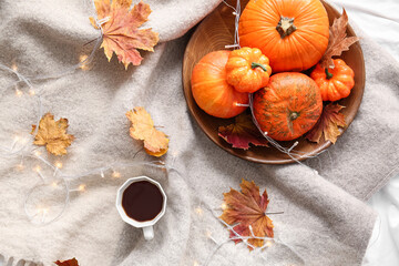 Pumpkins and cup of coffee on bed