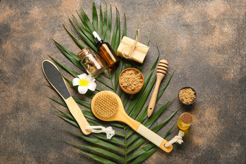 Composition with natural cosmetics, spa accessories and palm leaf on grunge background