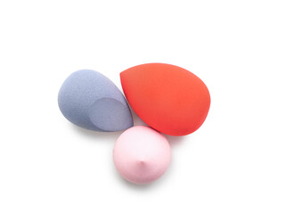 Stylish makeup sponges on white background