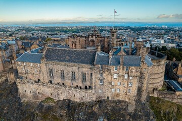 Aerial view. of Edinburgh Castle, situated on top of Castle Rock, dominates the skyline of the historic town below.  The castle is one of the most iconic and important historic castles in Scotland