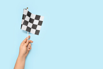 Female hand with racing flag on color background
