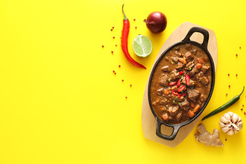 Dish with tasty beef curry on color background