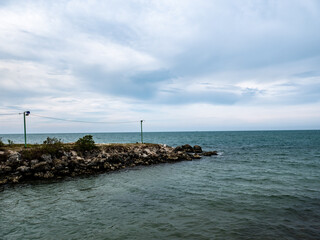 a beach consisting of rocks with a sea background and blue sky
