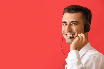 Answering male consultant of call center with headset on red background