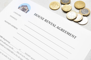 House rental agreement with coins on light background, closeup