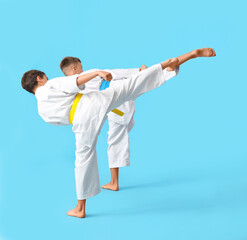 Obraz na płótnie Canvas Little boys practicing karate on color background