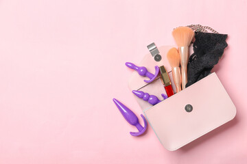 Sex toys, bag and cosmetics on color background