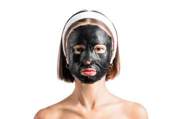 Young woman with activated charcoal mask on her face against white background